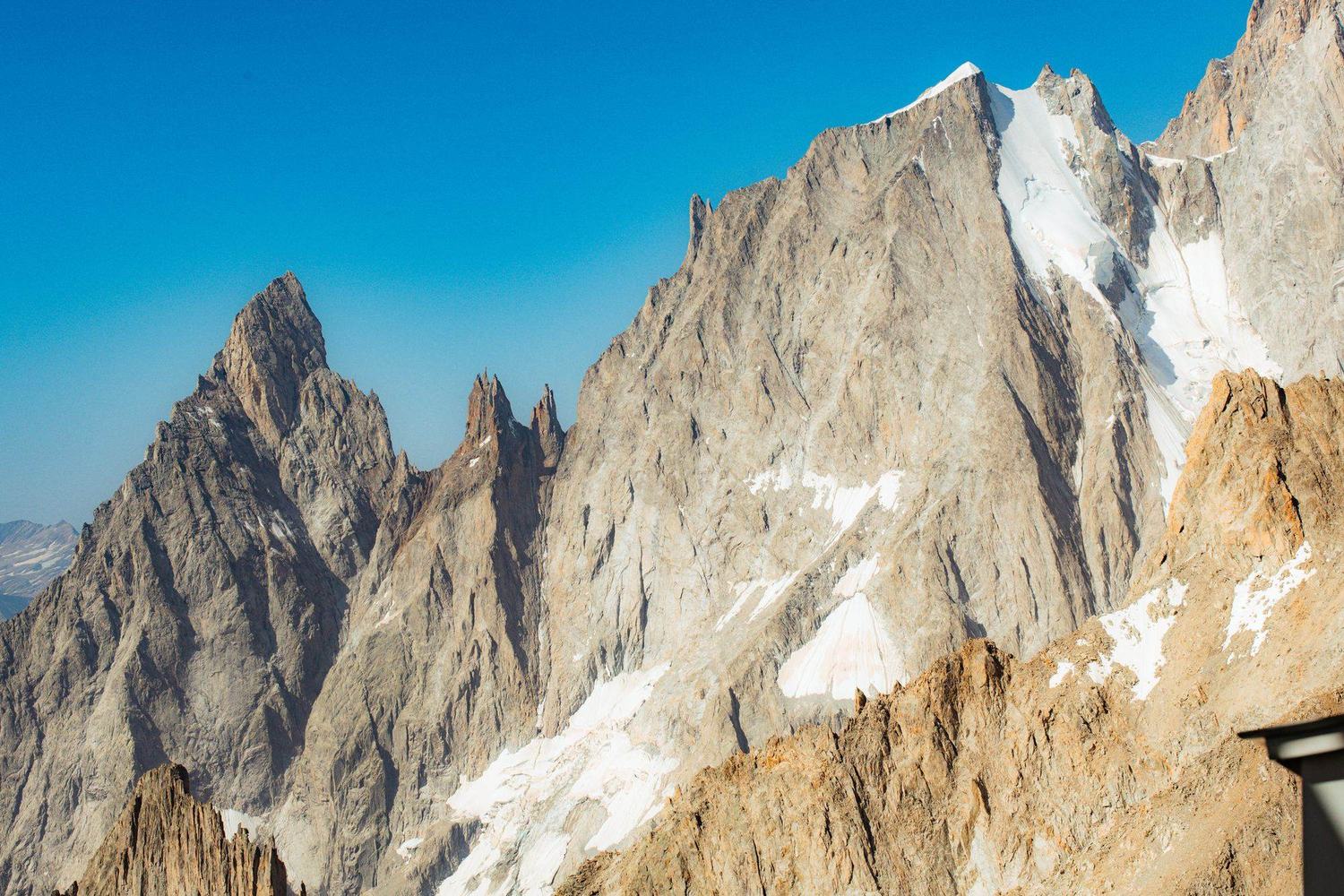 Arêtes rocheuses et glacier du massif du Mont-Blanc sous un ciel bleu
